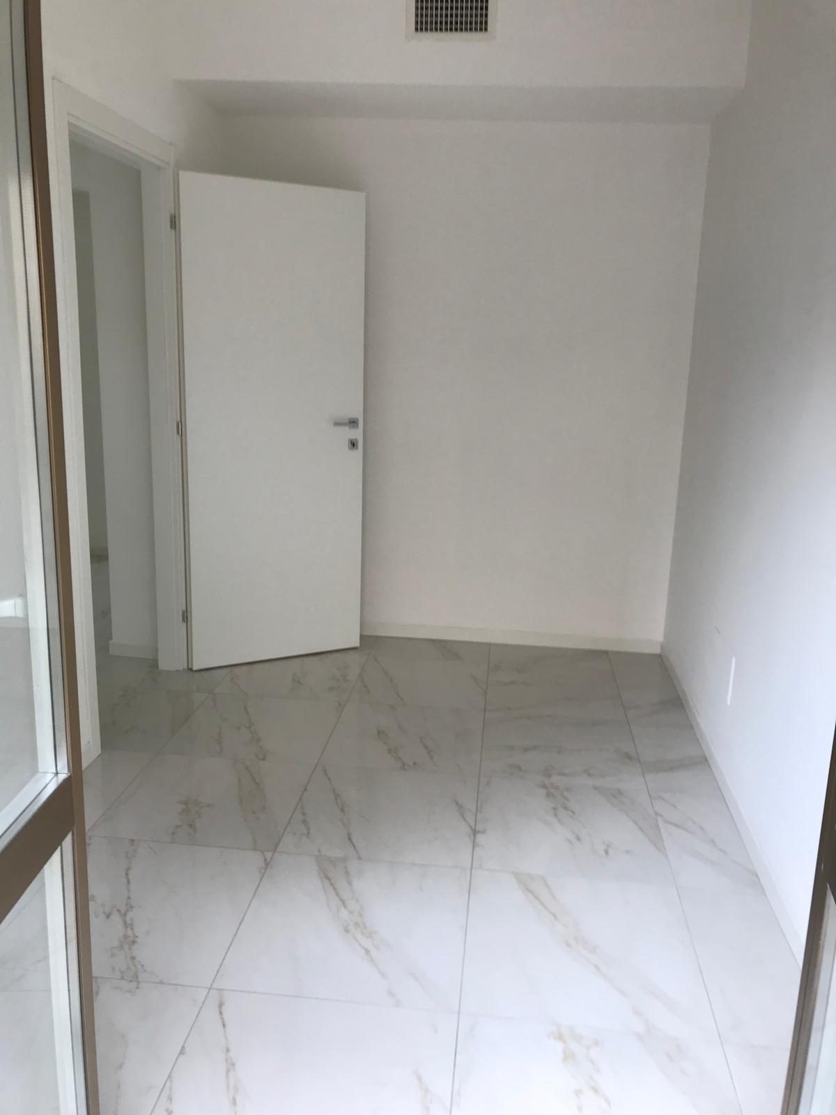 Camera con pavimento gres effetto marmo bianco e porte bianche