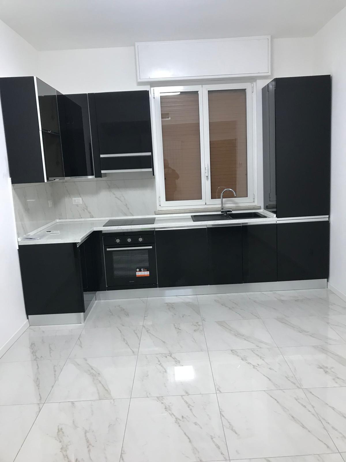 Cucina nera lucida con pavimento gres effetto marmo bianco